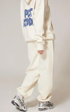 PrettyLittleThing Cream Sweatsuits*Premium Studio Print Cuffed Sweatpants